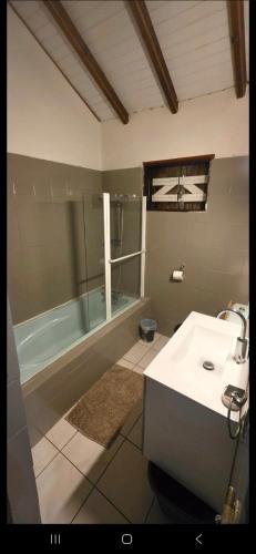 a bathroom with a shower and a sink and a tub at Au cœur de douenel bouillante cheques vacances acceptées in Bouillante