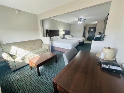 a hotel room with a couch and a bed and a desk at BridgePointe Inn & Suites by BPhotels, Lincoln I-80 & 27th St in Lincoln