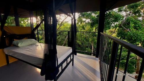 a porch with a bed on a balcony at Wildcat hostel Yala in Kataragama