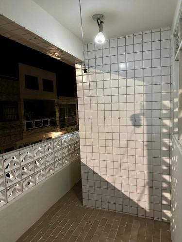 a bathroom with a shower with white tiled walls at Caruaru house in Caruaru