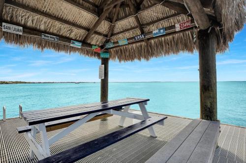 a picnic table on a pier next to the ocean at Paradise at Moon Bay in Key Largo
