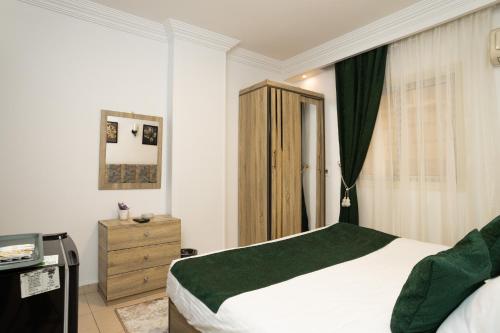 a bedroom with a bed and a wooden cabinet at Museum Land Boutique Hotel in Cairo