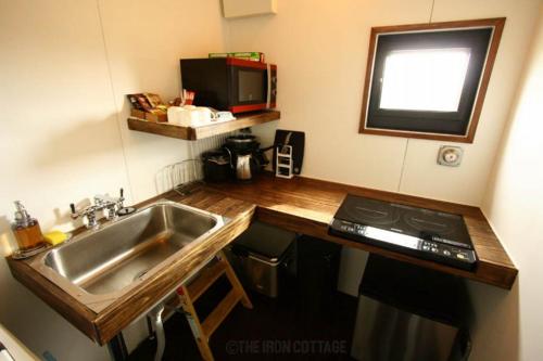 a small kitchen with a sink and a stove at Container Suite 75 in Nago