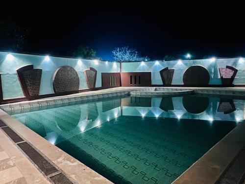 a swimming pool at night with lights at Hotel Green valley resort in Kota
