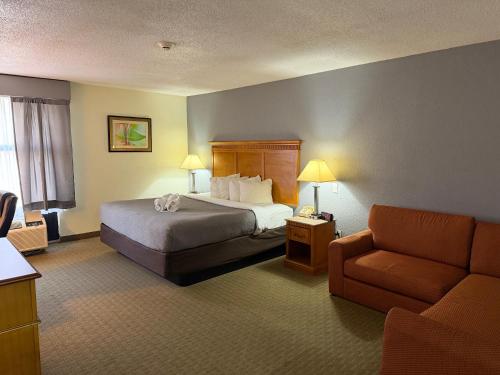 a hotel room with a bed and a couch at Lafayette Inn & Suites in Indianapolis