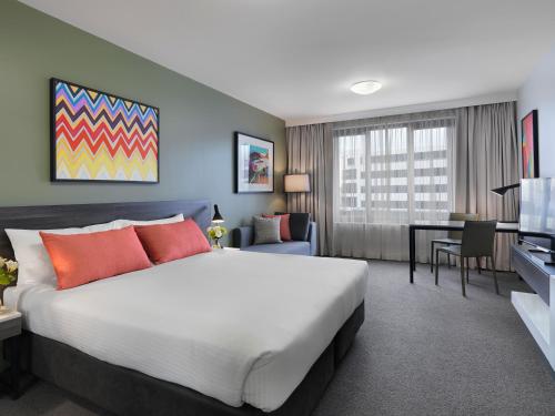 a hotel room with a large bed and a desk at Adina Apartment Hotel Sydney Airport in Sydney