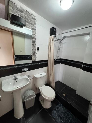 a bathroom with a white toilet and a sink at Santa Ana Home Cusco in Cusco