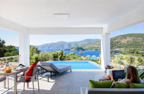 a living room with a view of a pool at Villa Del Mar in Vasiliki