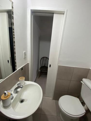 a bathroom with a white sink and a toilet at La Esquina AT in San Pedro