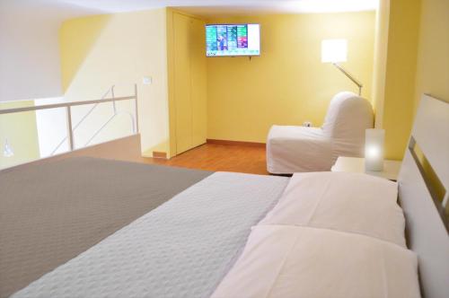 a bedroom with a bed and a tv on the wall at 1878 Sorrento Guest House in Sorrento