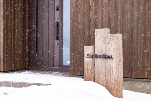 a sign in the snow in front of a building at Villa HIGASHIKAWA -Hokkaido- in Higashikawa