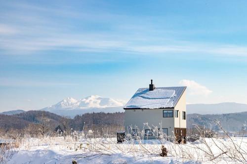 a house in a field with snow on it at Villa HIGASHIKAWA -Hokkaido- in Higashikawa
