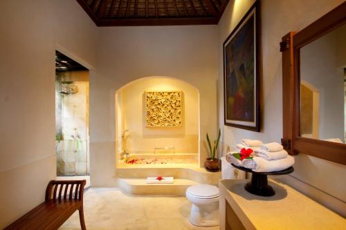 a bathroom with a toilet and a bath tub at Svarga Bebek Villas in Ubud