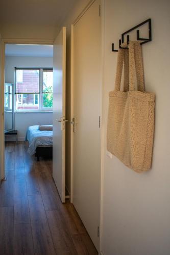 ein Zimmer mit einem Bett und einer Tragetasche an der Wand in der Unterkunft Cornfield in Arnhem