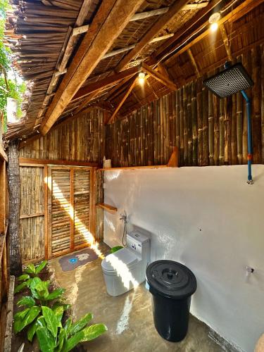 a bathroom with a toilet in a wooden building at Wonderland in Siquijor