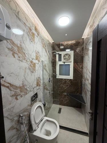 a bathroom with a toilet and a tv on the wall at Modern 4BR 3Bath Stylish Spacious in Madinaty