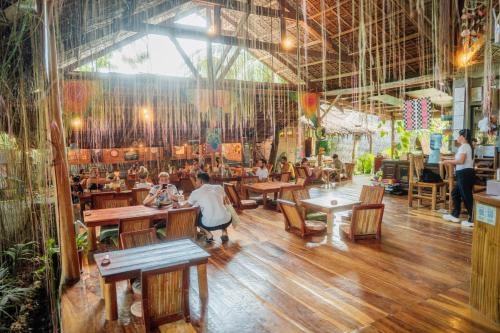 a group of people sitting at tables in a restaurant at Wonderland in Siquijor