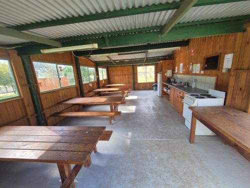 a row of tables in a kitchen with wooden benches at Bonnie Doon Caravan Park in Bonnie Doon