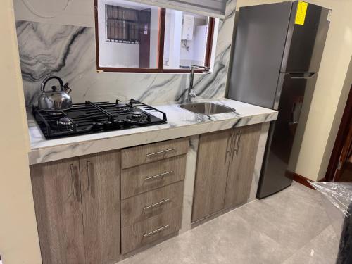 a kitchen with a stove and a sink in it at Suite ejecutiva con Parqueo Privado in Latacunga