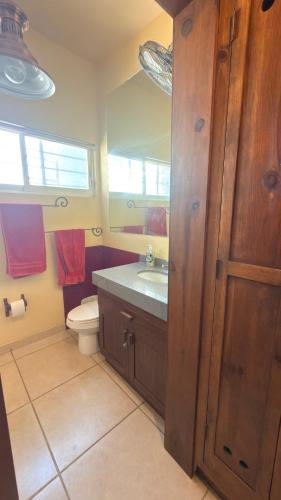 a bathroom with a sink and a toilet and a window at Hacienda en Primavera, descanso Familiar total in Puerto Vallarta