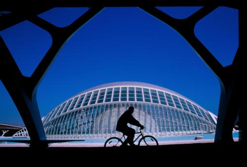 a man riding a bike in front of a building at Ibis Budget Valencia Aeropuerto in Manises