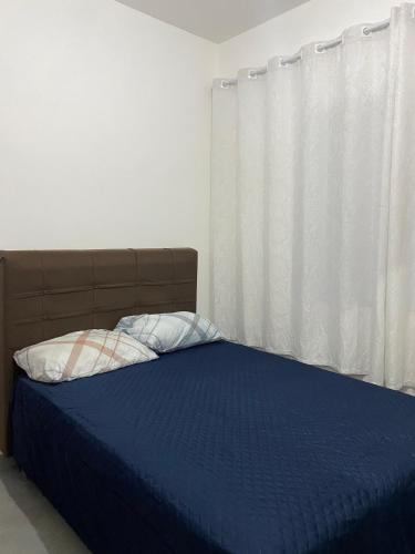 una camera da letto con un letto con una coperta blu e una finestra di Casa Diamante a Angelim