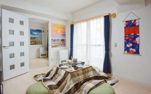 a living room with a table and a window at Carid Shiraishi In front of the station / Vacation STAY 4651 in Sapporo