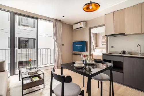 a kitchen and living room with a table and chairs at Tierra Residences in Bangkok in Bangkok