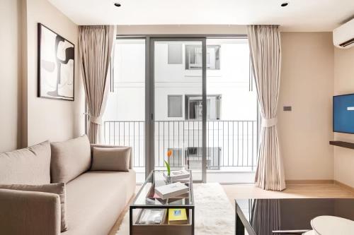 a living room with a couch and a tv at Tierra Residences in Bangkok in Bangkok