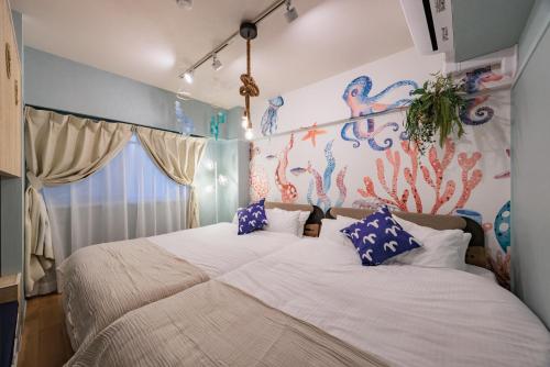 a bedroom with a large white bed with blue pillows at Minato Marine Stay in Nagoya