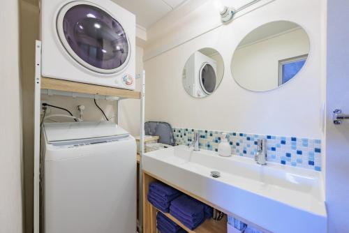 a bathroom with a sink and a washing machine at Minato Marine Stay in Nagoya