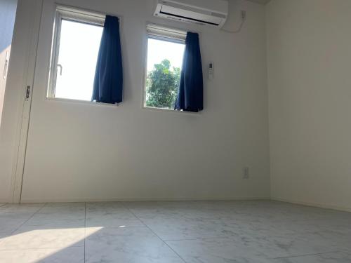 an empty room with two windows with blue curtains at Yuimaru - Vacation STAY 43049v in Bora