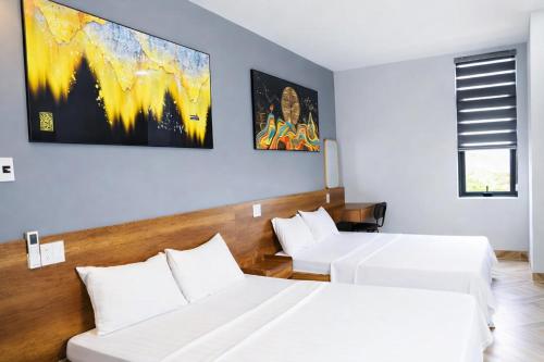 a hotel room with two beds and a couch at Hoa Dã Qùy Hotel 2 in Pleiku