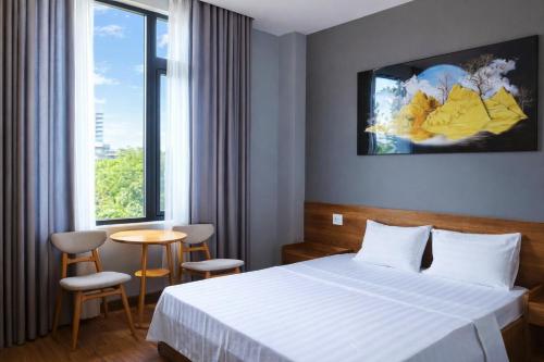 a hotel room with a bed and a table and a window at Hoa Dã Qùy Hotel 2 in Pleiku