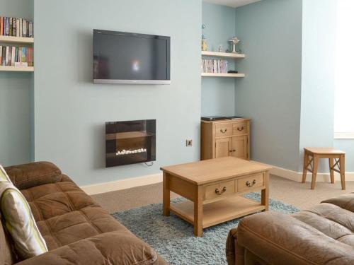 a living room with a couch and a table and a tv at Anchor's Away in Filey