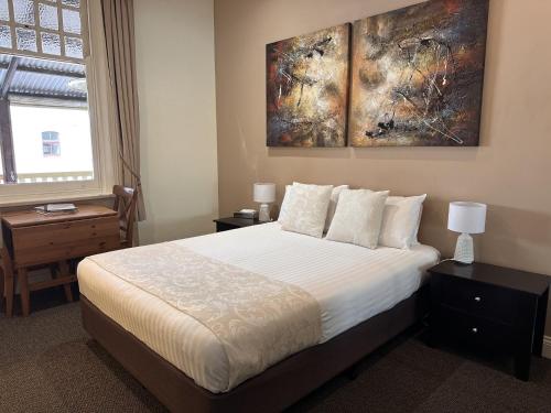 a bedroom with a bed and a painting on the wall at Balcony On Sixth Lodge in Murray Bridge