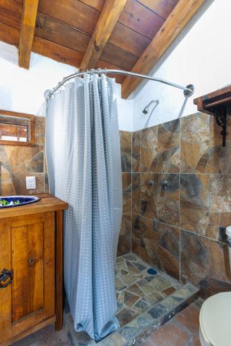 a bathroom with a shower with a shower curtain at Cabaña El Sitio in Huasca de Ocampo