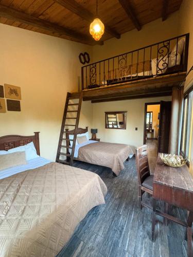 a bedroom with two beds and a loft at Cabañas Puerta del Bosque núm 2 in Mazamitla