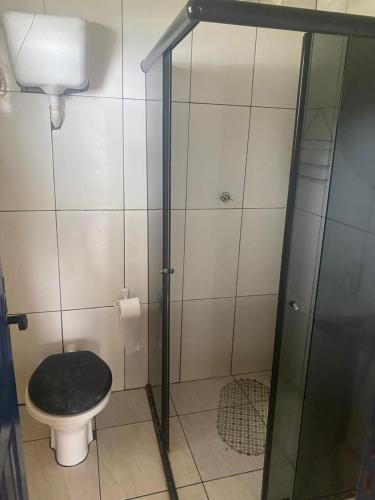 a bathroom with a toilet with a black seat at Cabana Maktub in Uruçuca