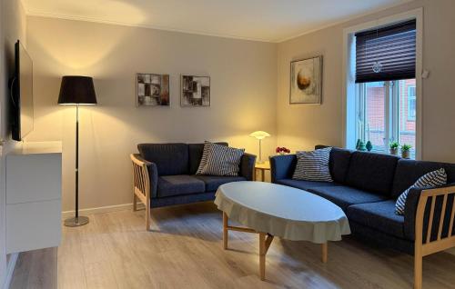 a living room with two blue couches and a table at Nice Home In Ansager With Wifi in Ansager