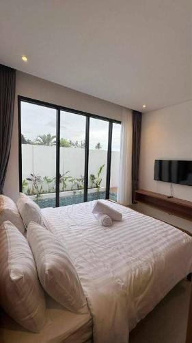 a bedroom with a large bed with a large window at Alijul Private villa in Munggu