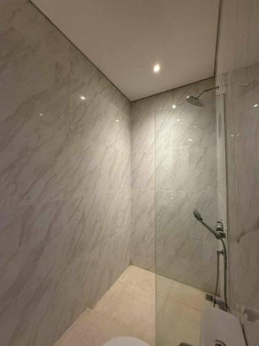 a bathroom with a glass shower with a toilet at Alijul Private villa in Munggu