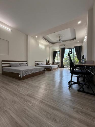 a large bedroom with two beds and a desk at THHomestay in Danang
