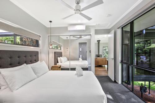 a bedroom with a white bed and a mirror at Under the Pecans - 2BR Retreat with Peaceful Scenic Views in Woombye
