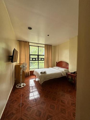 a bedroom with a bed and a large window at Hotel 45 Extension in Baguio