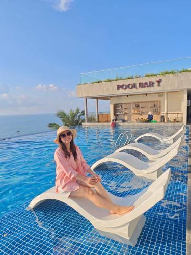 a woman sitting on a wave pool ride at a resort at Apec Mandala Imperial Ocean Tower Mui Ne in Mui Ne