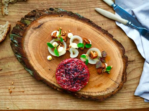 a plate of food on a wooden cutting board at Natura Mazur Resort & Conference in Warchały