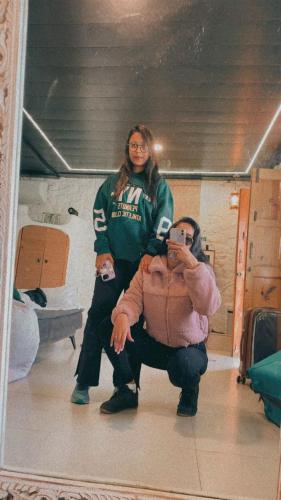 a woman taking a picture of a man in a mirror at Cob House in Mount Ābu