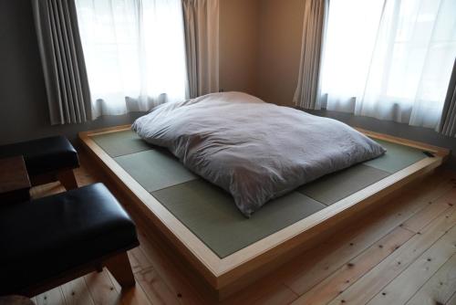 a bed on a wooden platform in front of a window at 宿ストロ Trip to Naoshima, Teshima 5-min walk from Uno Port in Tamano