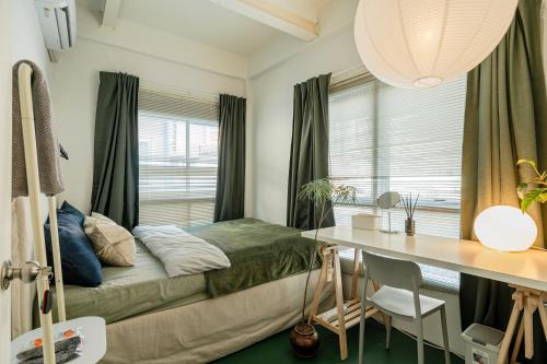 a bedroom with a bed and a desk and a window at nap in a blue moon in Bangkok
